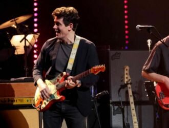 John Mayer jouant de la guitare sur scène