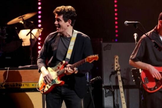 John Mayer jouant de la guitare sur scène