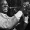 Louis Armstrong souriant et tenant sa trompette